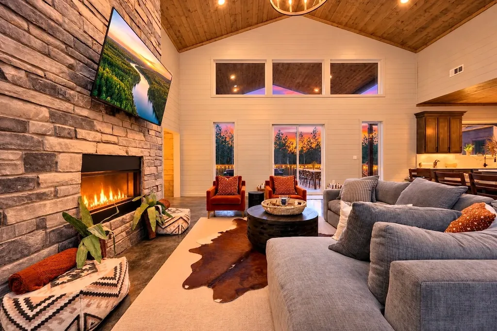 Miko Chukka — High vaulted ceilings, a stone gas fireplace, and a deep sectional make this living room a comfortable gathering spot with direct access to the deck.