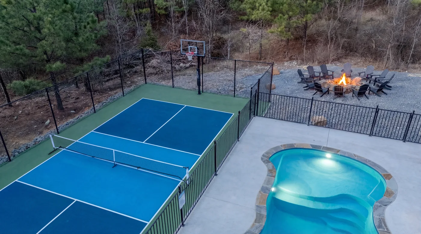 Aerial view of The Jade's pool, pickleball court, basketball hoop, and fire pit in Broken Bow